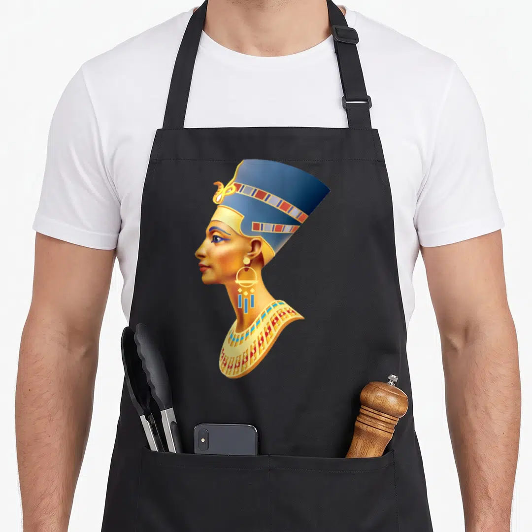 Queen egyptian apron - Realistic profile of an Egyptian woman wearing a blue crown and gold collar facing left — shown on a black cotton canvas apron against a white background
