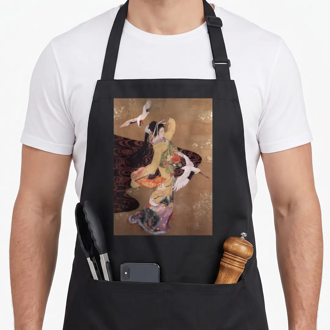 Dance crane apron - Woman in kimono and two cranes in flight on gold background with yellow, purple, and brown details — shown on a black cotton canvas apron against a white background