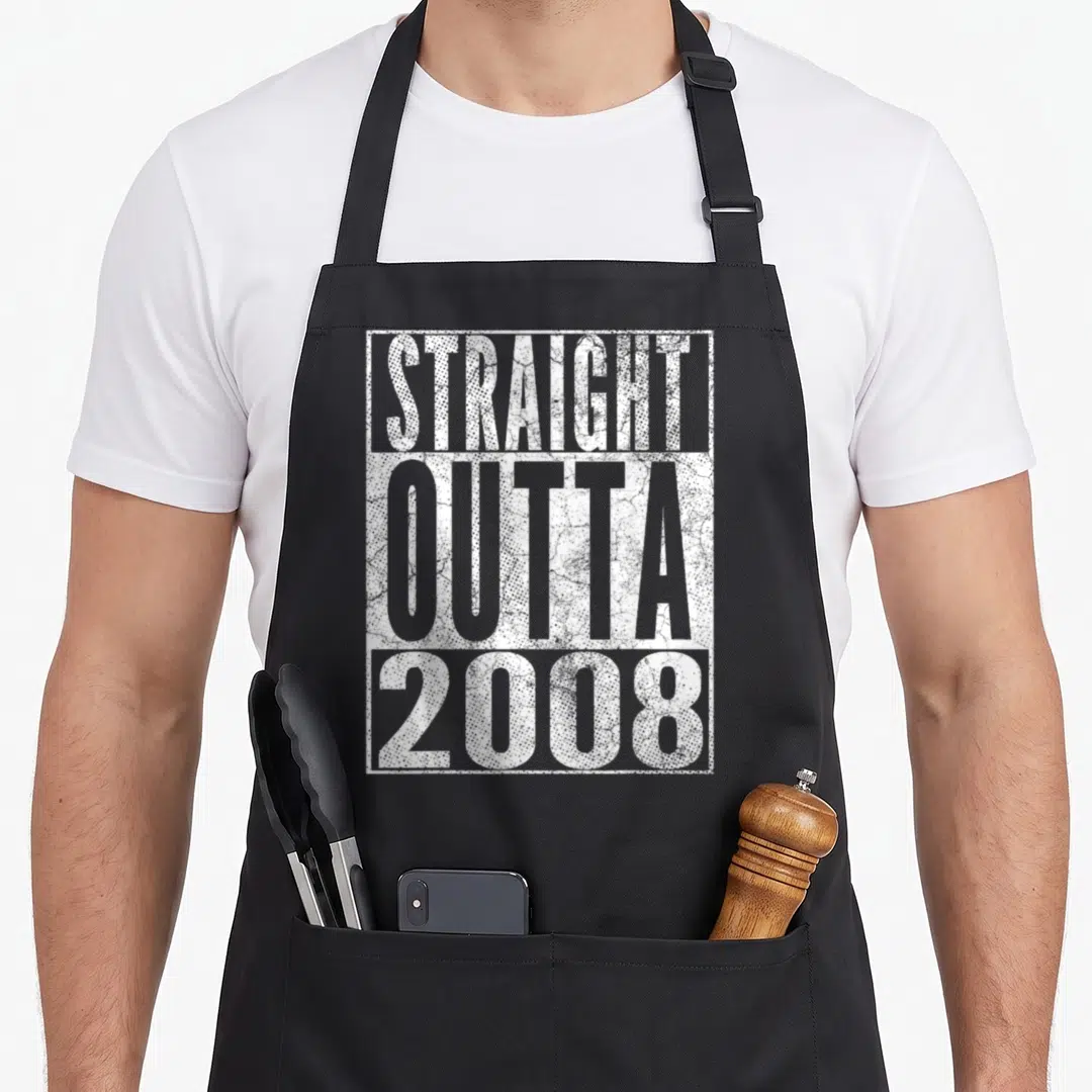 Outta birthday apron - White distressed text STRAIGHT OUTTA 2008 stacked in rectangular border — shown on a black cotton canvas apron against a white background