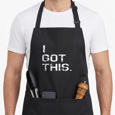 Cancer genetics apron - White stacked typography reading I GOT THIS with distressed stencil effect — shown on a black cotton canvas apron against a white background