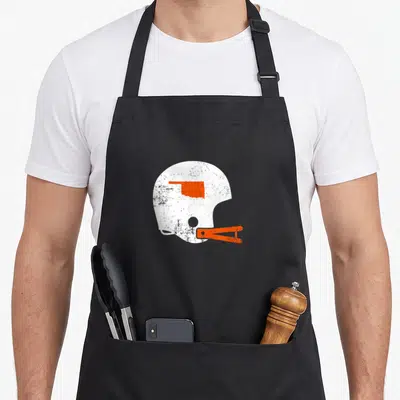 Helmet state football apron - Distressed white football helmet with orange Oklahoma map and face mask graphic — shown on a black cotton canvas apron against a white background