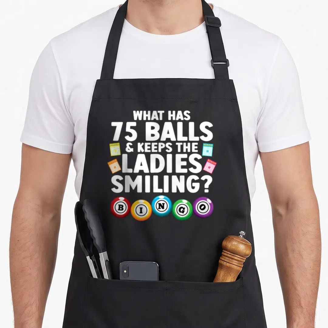 Vintage player bingo apron - White text asks about 75 balls with four cards and five colored BINGO spheres — shown on a black cotton canvas apron against a white background