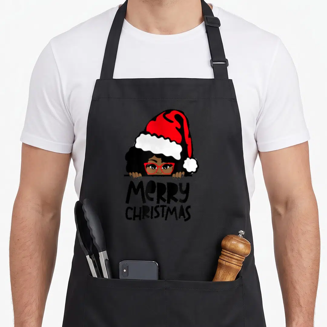 Melanin mrs apron - Woman in red Santa hat peeking over line above stacked Merry Christmas text in cartoon style — shown on a black cotton canvas apron against a white background