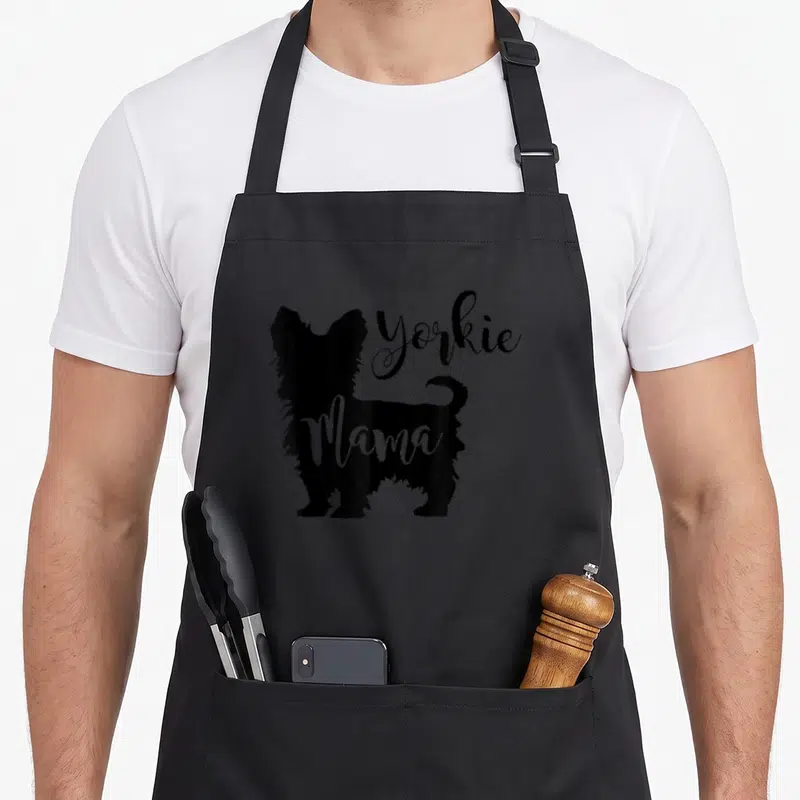 Profile yorkie apron - Black Yorkshire Terrier silhouette with white Mama text overlay — shown on a black cotton canvas apron against a white background