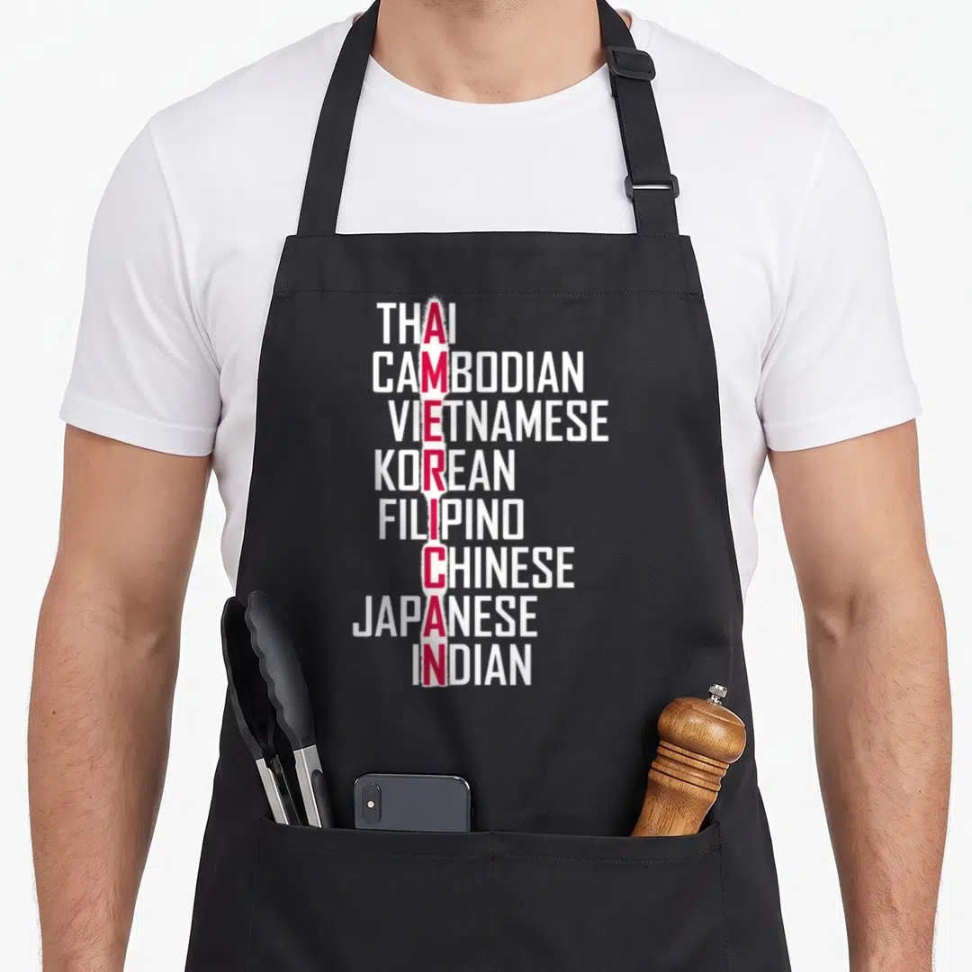 Pride asian apron - Vertical stack of Asian nationalities in white text with red American lettering on grey background — shown on a black cotton canvas apron against a white background