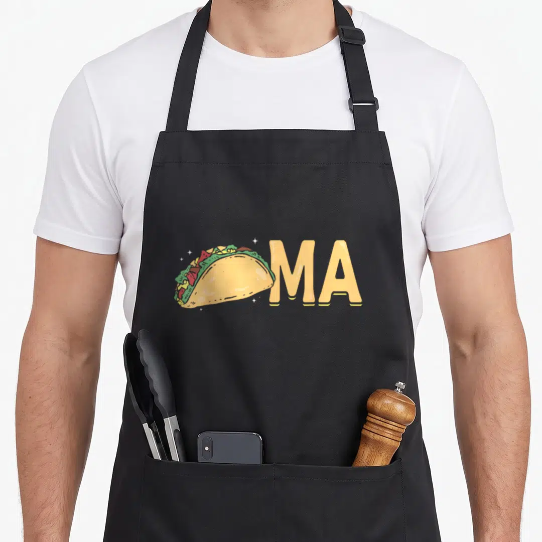 Washington taco apron - Cartoon taco illustration next to yellow MA text with white sparkles — shown on a black cotton canvas apron against a white background