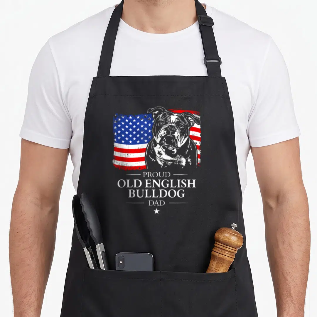Proud english american flag apron - Bulldog portrait over distressed red white blue flag with stacked text PROUD OLD — shown on a black cotton canvas apron against a white background