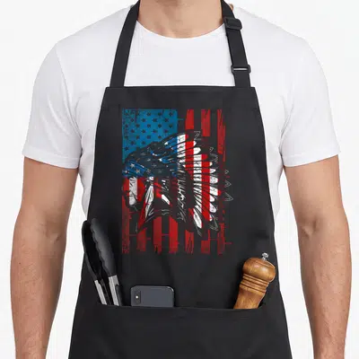 Flag heritage native american aprons - Distressed profile of Native American chief with headdress over red white — shown on a black cotton canvas apron against a white background