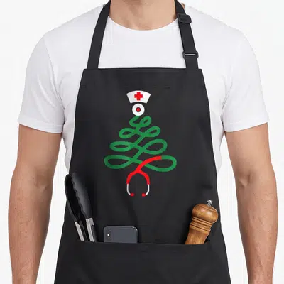 Stethoscope christmas tree apron - Green coiled stethoscope tree shape with red tubing and white nurse cap topper — shown on a black cotton canvas apron against a white background