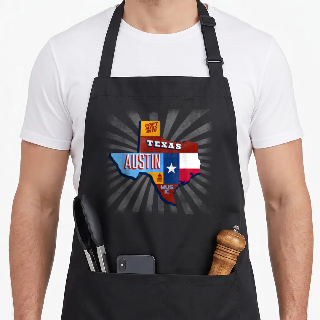 Festival texas aprons - Retro Texas map with Don't Mess With Austin Music text in red white blue yellow — shown on a black cotton canvas apron against a white background