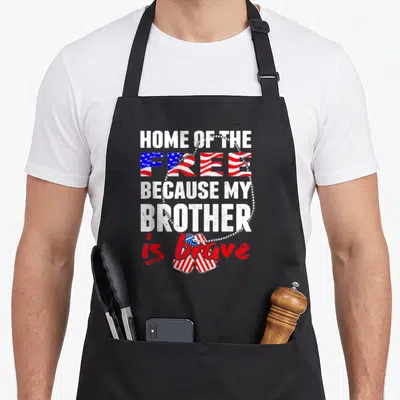 Brother grunt apron - Distressed text reading Home of the Free Because My Brother is brave with US flag heart and dog — shown on a black cotton canvas apron against a white background