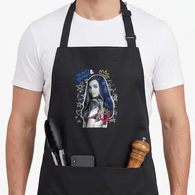 Descendant summer mode apron - BEAUTY BRAINS text, blue starry hair woman, gold crown, red heart, white scribbles — shown on a black cotton canvas apron against a white background