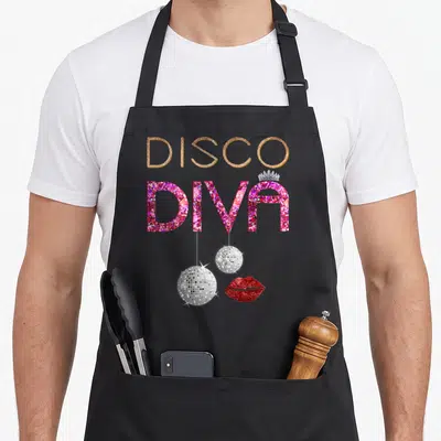 Diva world music apron - Gold DISCO and pink DIVA text with silver disco balls and red lips — shown on a black cotton canvas apron against a white background