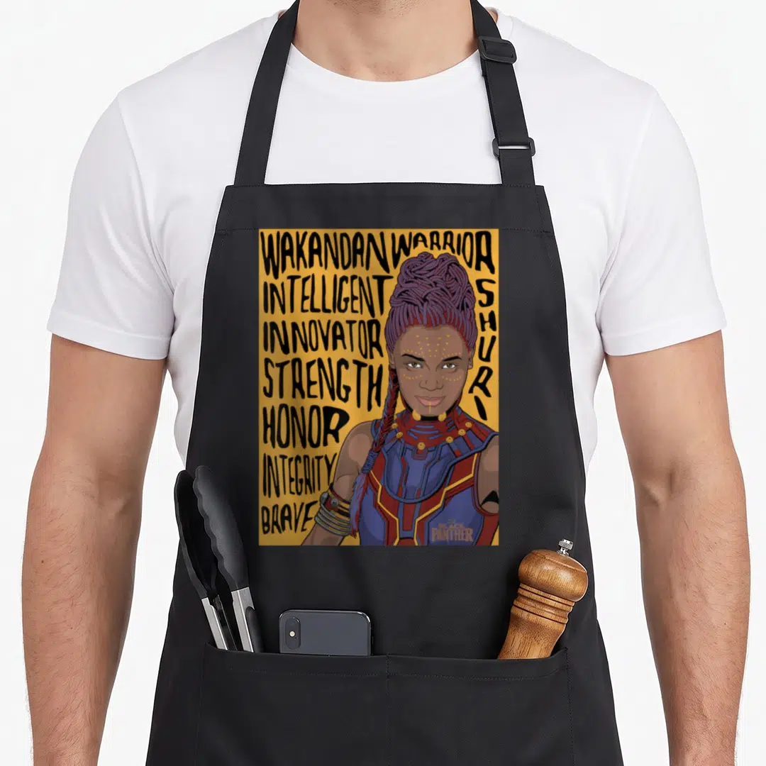 Shuri panther apron - Cartoon Shuri portrait with stacked text Intelligent Innovator Strength Honor Integrity Brave — shown on a black cotton canvas apron against a white background