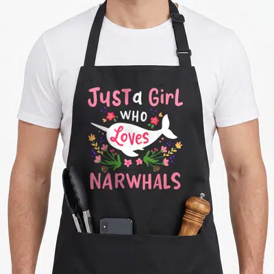 Funny narwhal apron - White narwhal with pink text and flowers reading Just a Girl Who Loves Narwhals — shown on a black cotton canvas apron against a white background