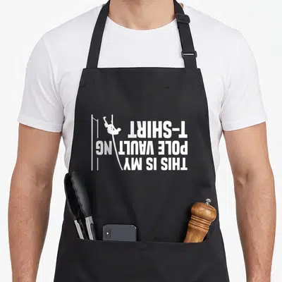 Vaulting track apron - White rotated text THIS IS MY POLE VAULTING T-SHIRT with minimalist pole vaulter silhouette — shown on a black cotton canvas apron against a white background