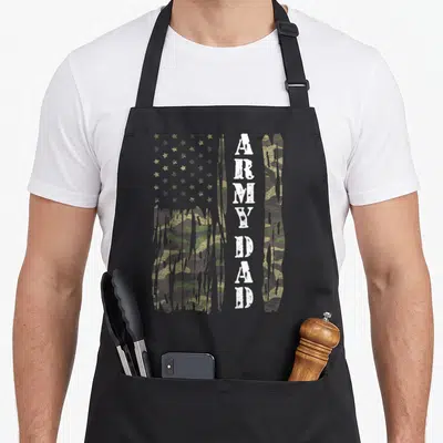 Flag army father day apron - Distressed camo USA flag with dripping edges and vertical white ARMY DAD text — shown on a black cotton canvas apron against a white background