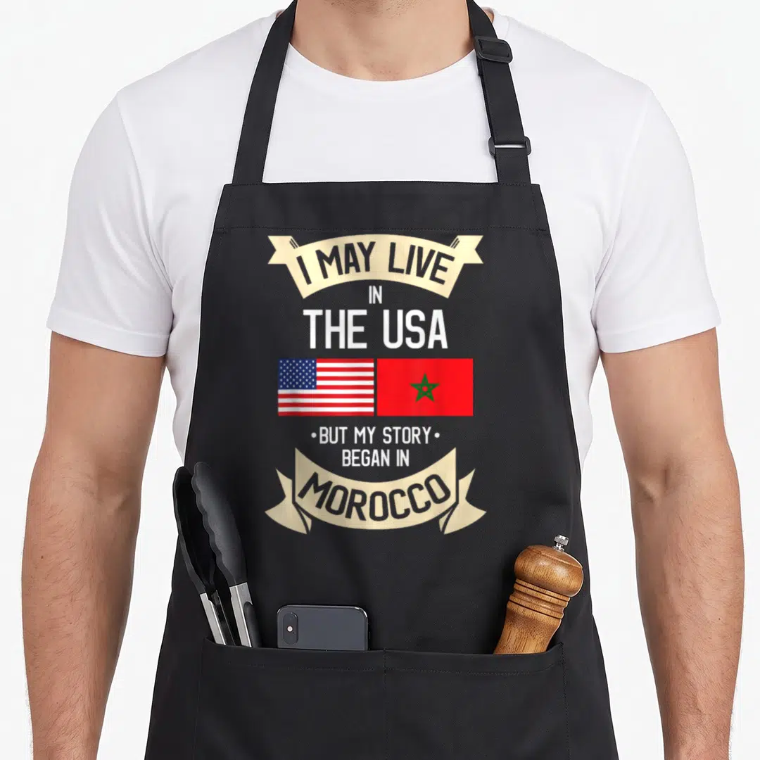 Morocco moroccan american flag apron - Stacked text with US and Morocco flags side-by-side inside beige ribbons — shown on a black cotton canvas apron against a white background