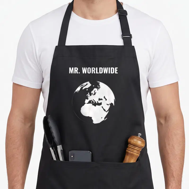 Worldwide mr apron - White MR. WORLDWIDE text above a minimalist white earth globe on grey background — shown on a black cotton canvas apron against a white background