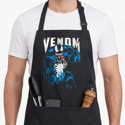 Tongue bloody apron - Distressed VENOM text above lunging blue and white character with red tongue — shown on a black cotton canvas apron against a white background