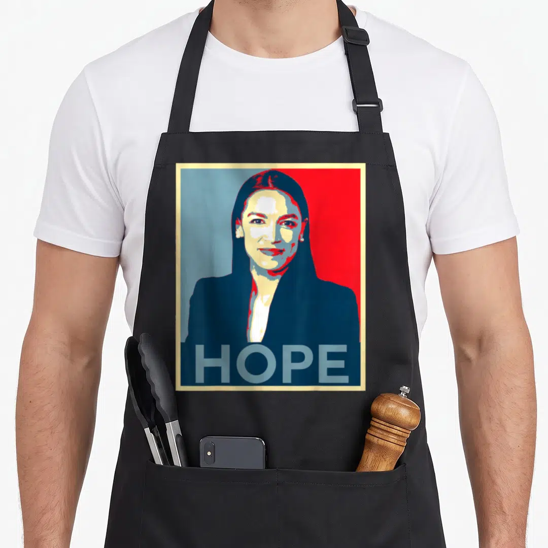 Alexandria hope apron - Retro portrait of woman with HOPE text on red blue background — shown on a black cotton canvas apron against a white background
