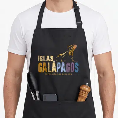 Galapago iguana apron - Gradient iguana above stacked Islas Galapagos text in orange blue purple and cream distressed — shown on a black cotton canvas apron against a white background