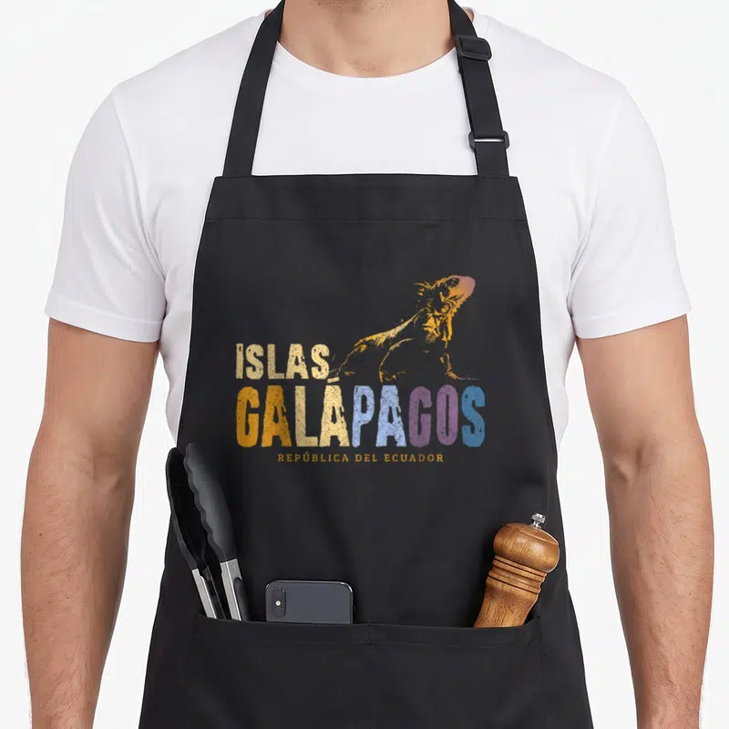 Galapago iguana apron - Gradient iguana above stacked Islas Galapagos text in orange blue purple and cream distressed — shown on a black cotton canvas apron against a white background