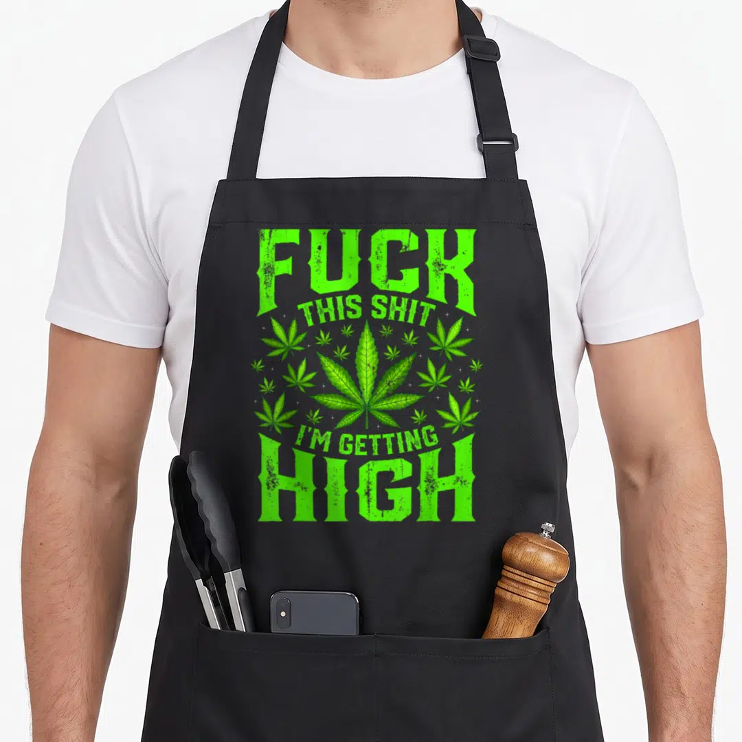 Getting pipe mom apron - Green cannabis leaf surrounded by smaller leaves and white stars with distressed text — shown on a black cotton canvas apron against a white background