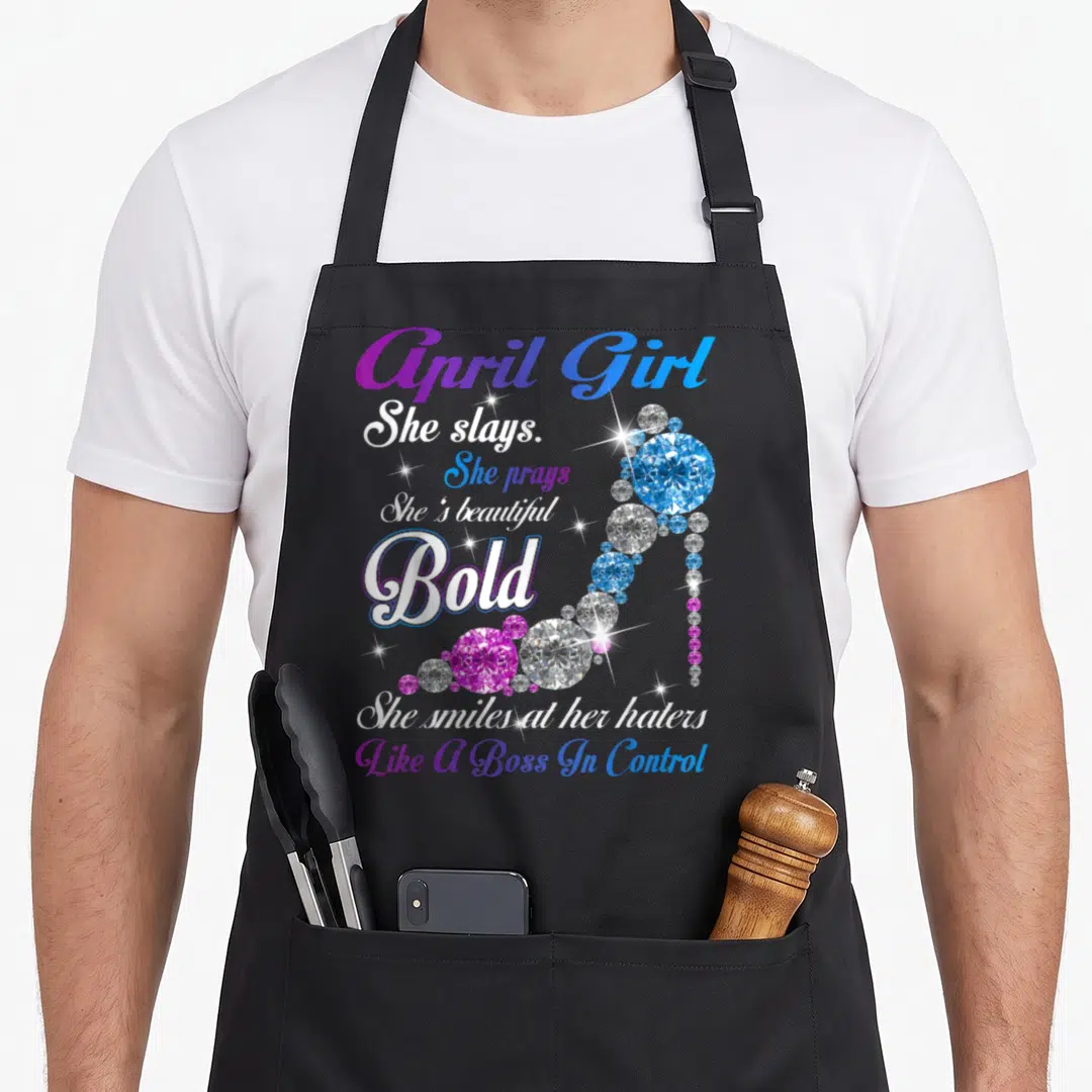 She april apron - April Girl She Slays text and diamond high heel shoe in purple blue white — shown on a black cotton canvas apron against a white background