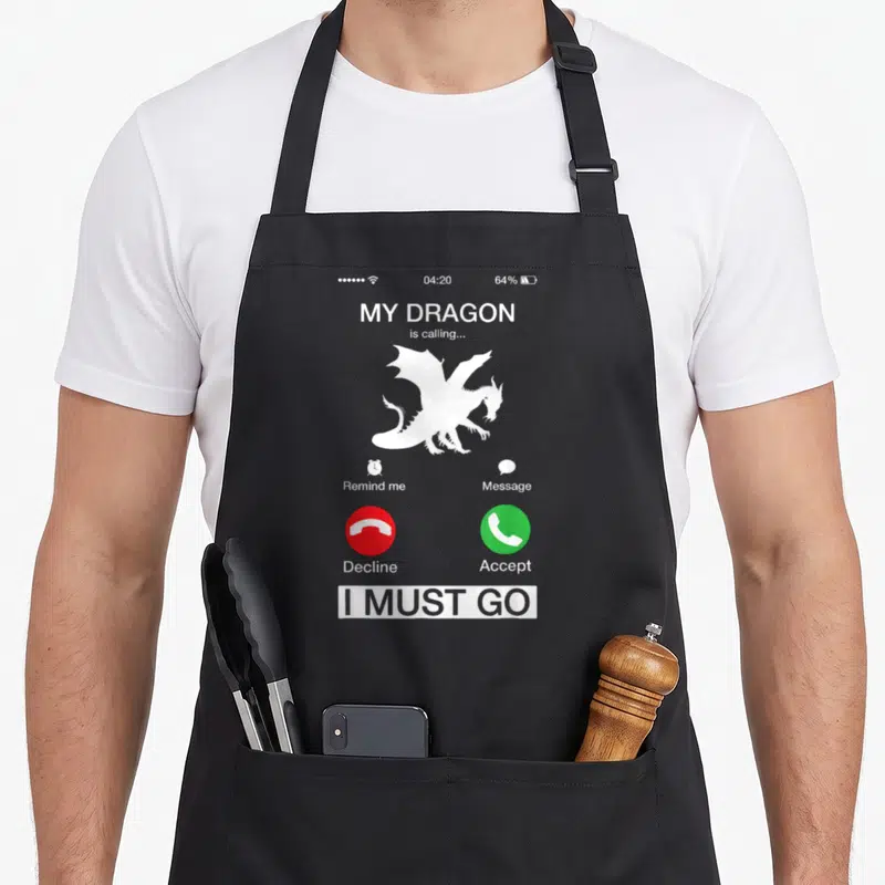 Calling dragon apron - Smartphone call screen with white dragon silhouette, red decline green accept buttons, and I — shown on a black cotton canvas apron against a white background