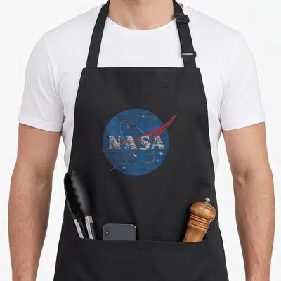 Funny distressed nasa apron - Distressed blue NASA logo with red swoosh and white stars on black fabric — shown on a black cotton canvas apron against a white background