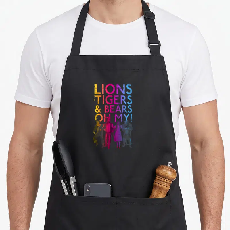 Wizard bear apron - Lions Tigers Bears Oh My text with four watercolor characters in yellow pink blue purple gradient — shown on a black cotton canvas apron against a white background