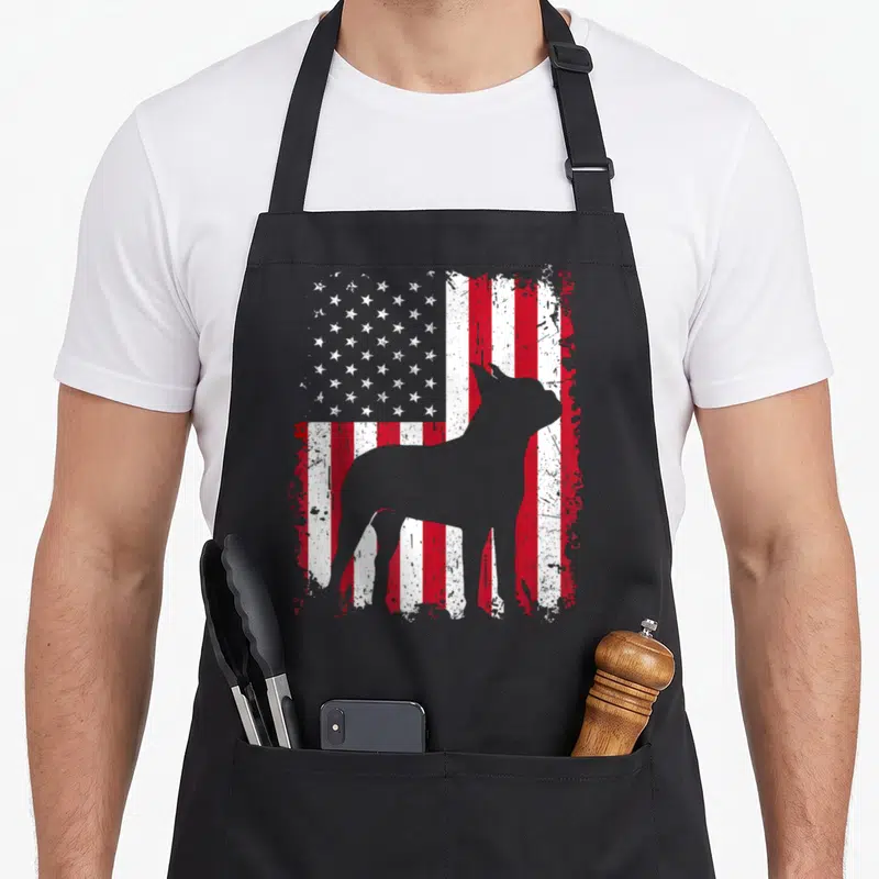 Terrier 4th of july apron - Grey dog silhouette standing before a distressed red white and blue American flag pattern — shown on a black cotton canvas apron against a white background