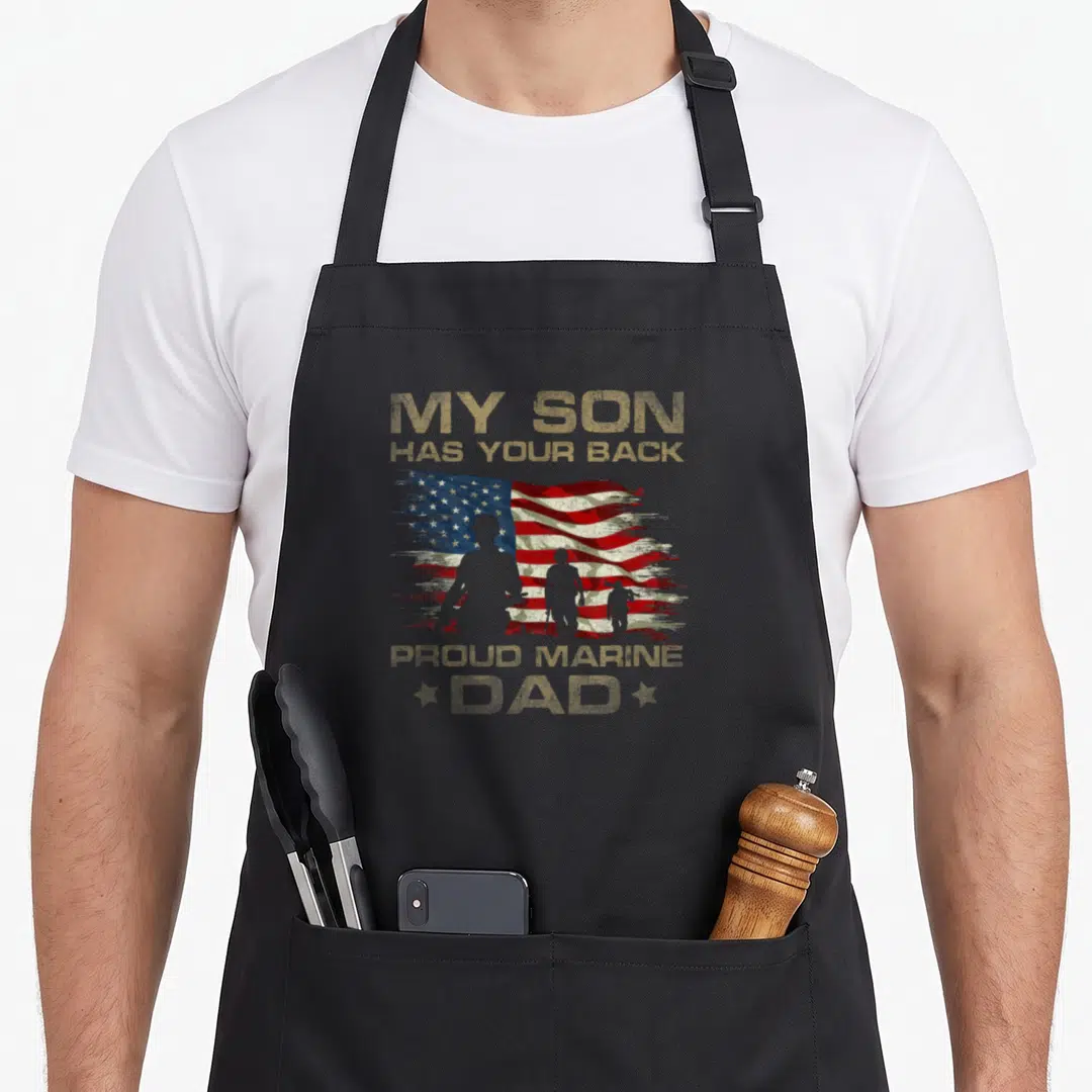 Son camouflage apron - Distressed USA flag with three soldier silhouettes and My Son Has Your Back text — shown on a black cotton canvas apron against a white background