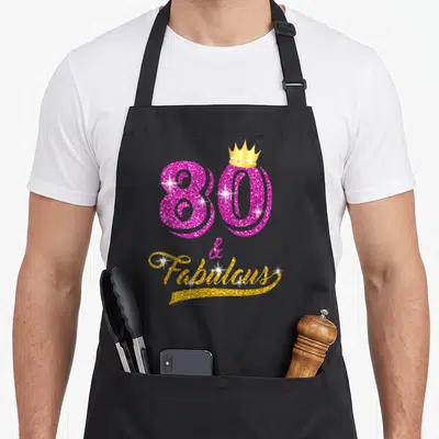 Fabulous yrs birthday apron - Pink glitter 80 with gold crown and gold Fabulous script — shown on a black cotton canvas apron against a white background