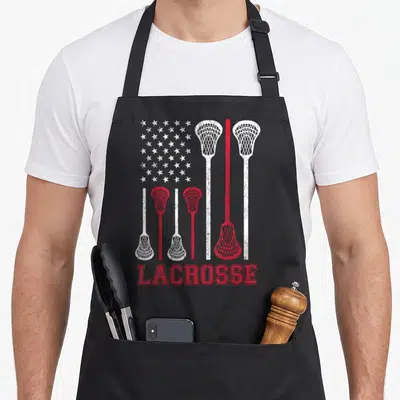 Lax american flag apron - Red and white distressed flag design formed by lacrosse stick silhouettes and stars — shown on a black cotton canvas apron against a white background