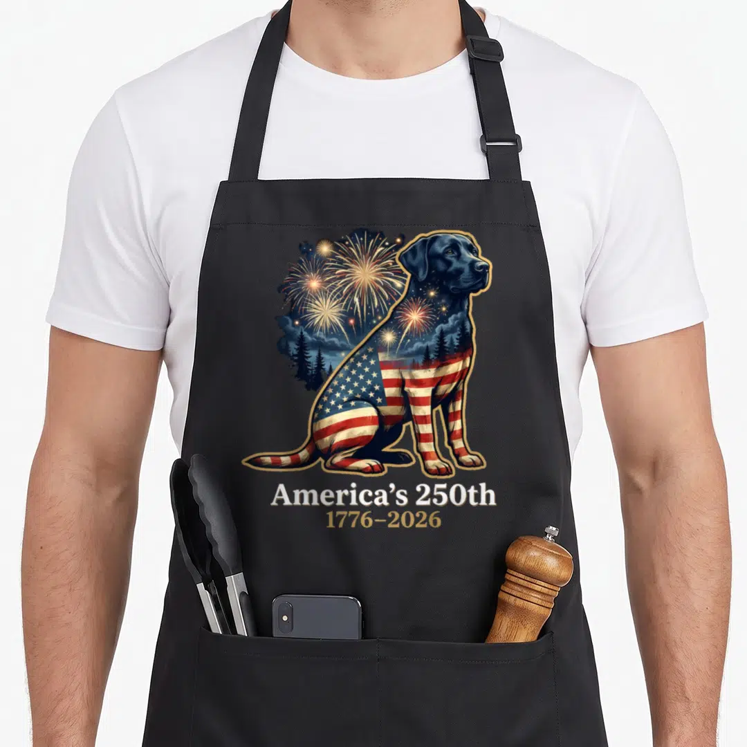 Americas labrador apron - Realistic black dog with US flag pattern and fireworks text America's 250th 1776-2026 — shown on a black cotton canvas apron against a white background