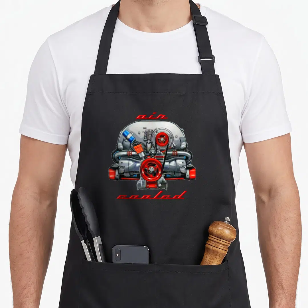Boxer air dad apron - Realistic silver engine with red accents and two lines of red text reading air cooled — shown on a black cotton canvas apron against a white background