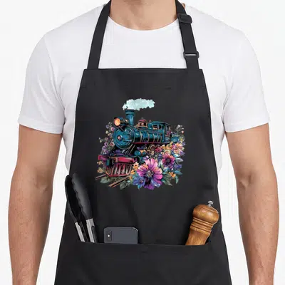 Flower steam train apron - Teal steam locomotive surrounded by pink and purple flowers with rising smoke cloud — shown on a black cotton canvas apron against a white background