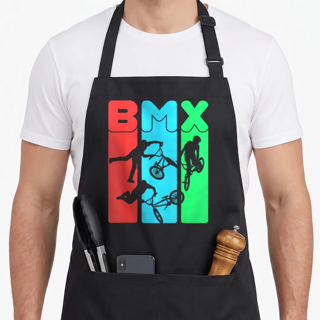 Eat bicycle apron - BMX text in red blue green bars with grey rider silhouettes — shown on a black cotton canvas apron against a white background