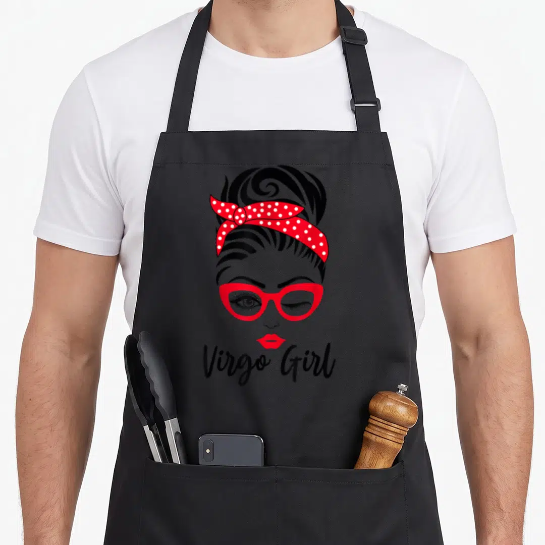 Virgo face apron - Cartoon winking woman face red glasses polka dot bandana Virgo Girl text — shown on a black cotton canvas apron against a white background