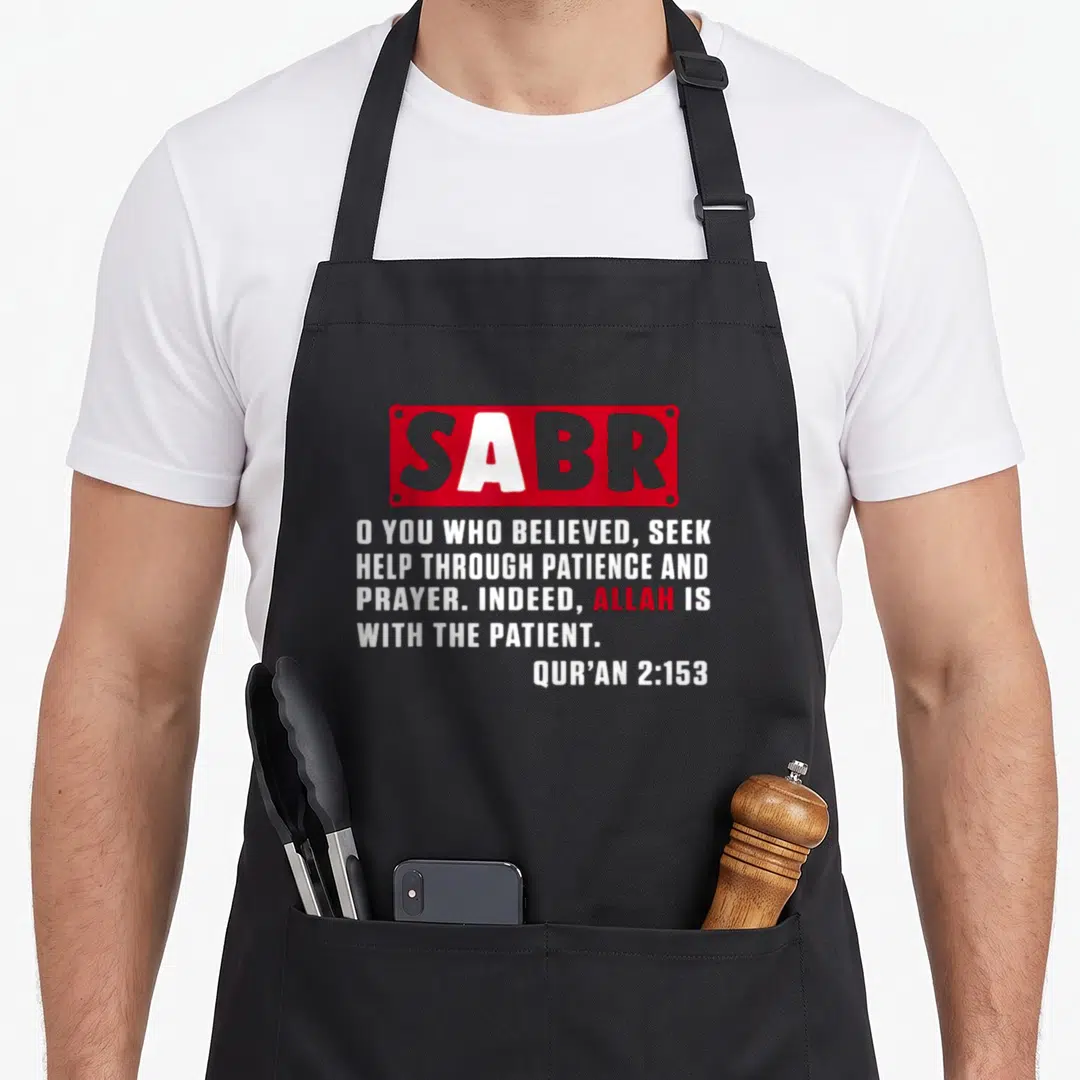 Sabr quran apron - SABR in red box above white Qur'an 2:153 text with red ALLAH highlight — shown on a black cotton canvas apron against a white background