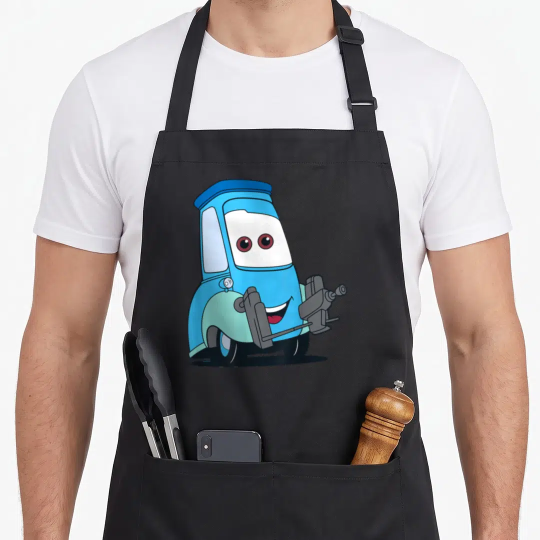 Guido car apron - Blue cartoon forklift character with red eyes and grey forks centered on fabric — shown on a black cotton canvas apron against a white background