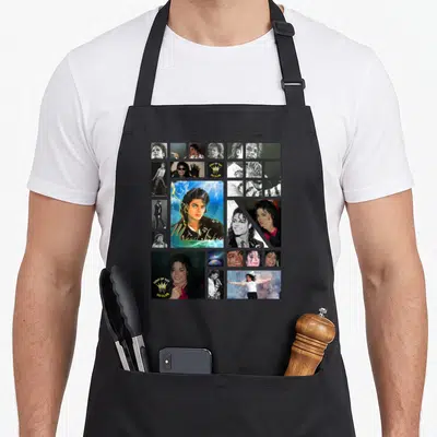 Funny jackson michaels apron - Collage of Michael Jackson photos with KING OF POP text and crown logo — shown on a black cotton canvas apron against a white background
