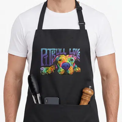 Funny pitbull pit bull apron - Multicolored cartoon pitbull head with paws and purple PITBULL LOVE text — shown on a black cotton canvas apron against a white background
