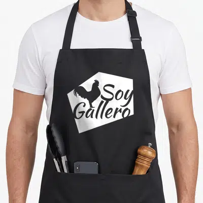 Soy gallero rooster apron - Grey rooster silhouette and Soy Gallero text on white polygon — shown on a black cotton canvas apron against a white background