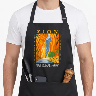 Zion utah girl apron - Retro orange canyon illustration with ZION and NATIONAL PARK text and vertical Established 1919 — shown on a black cotton canvas apron against a white background