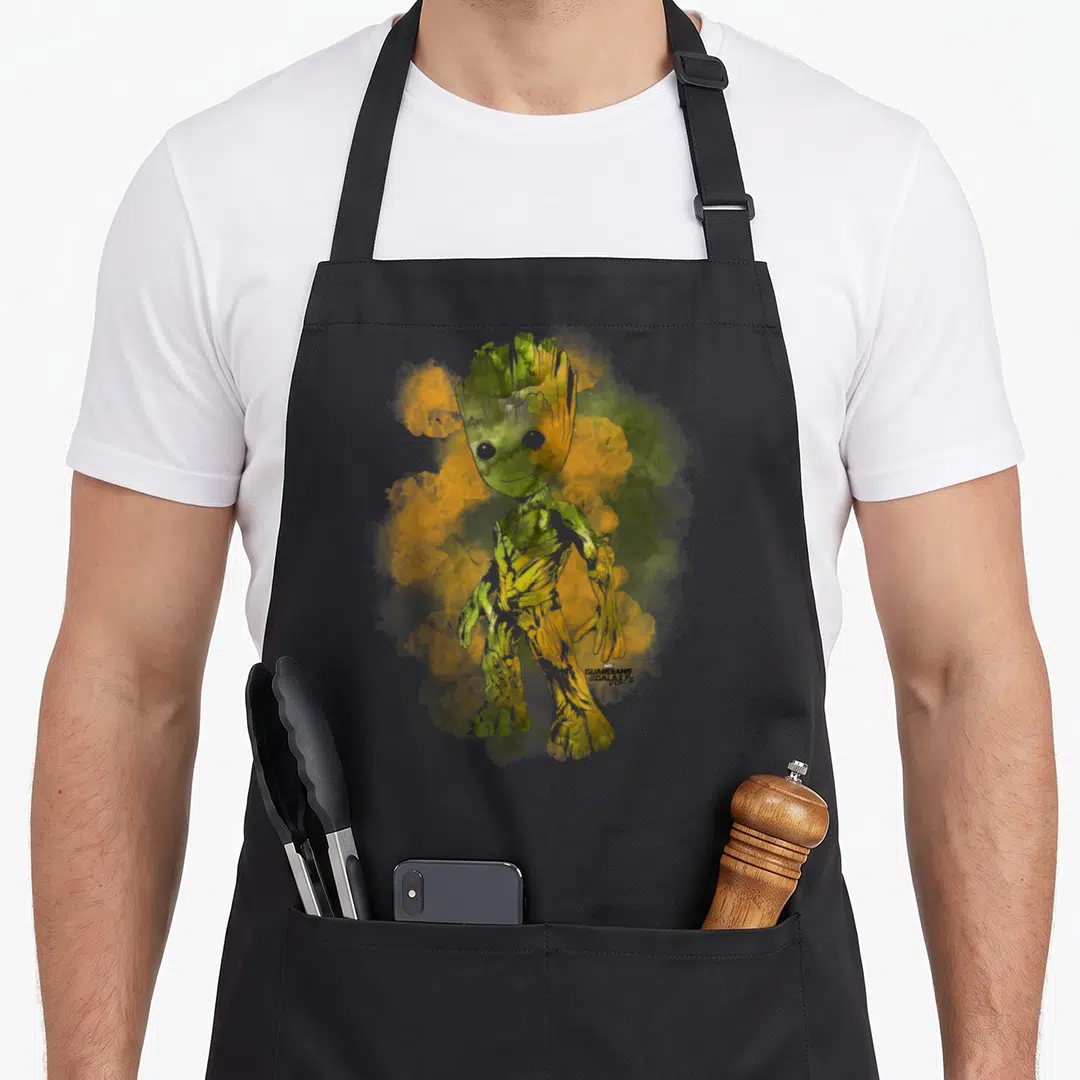 Guardian nebula apron - Groot watercolor illustration with green yellow orange smoke and Guardians of the Galaxy Vol 2 — shown on a black cotton canvas apron against a white background