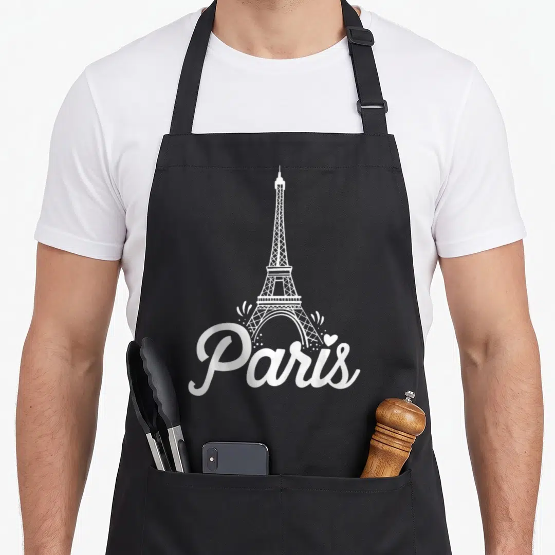 France eiffel paris apron - White minimalist Eiffel Tower illustration above Paris script with heart and sparkles — shown on a black cotton canvas apron against a white background