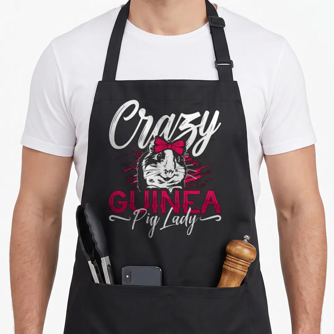 Zoo crazy guinea lady apron - Cartoon guinea pig wearing a pink bow under Crazy GUINEA Pig Lady text — shown on a black cotton canvas apron against a white background